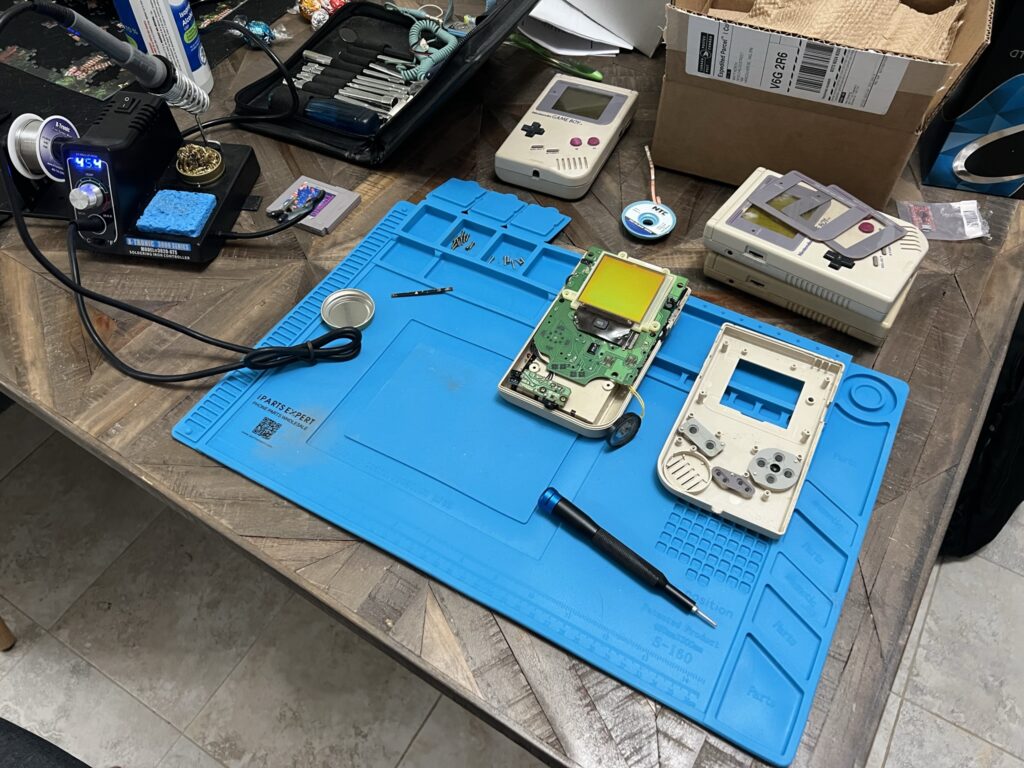 An opened Game Boy sat on a work mat.